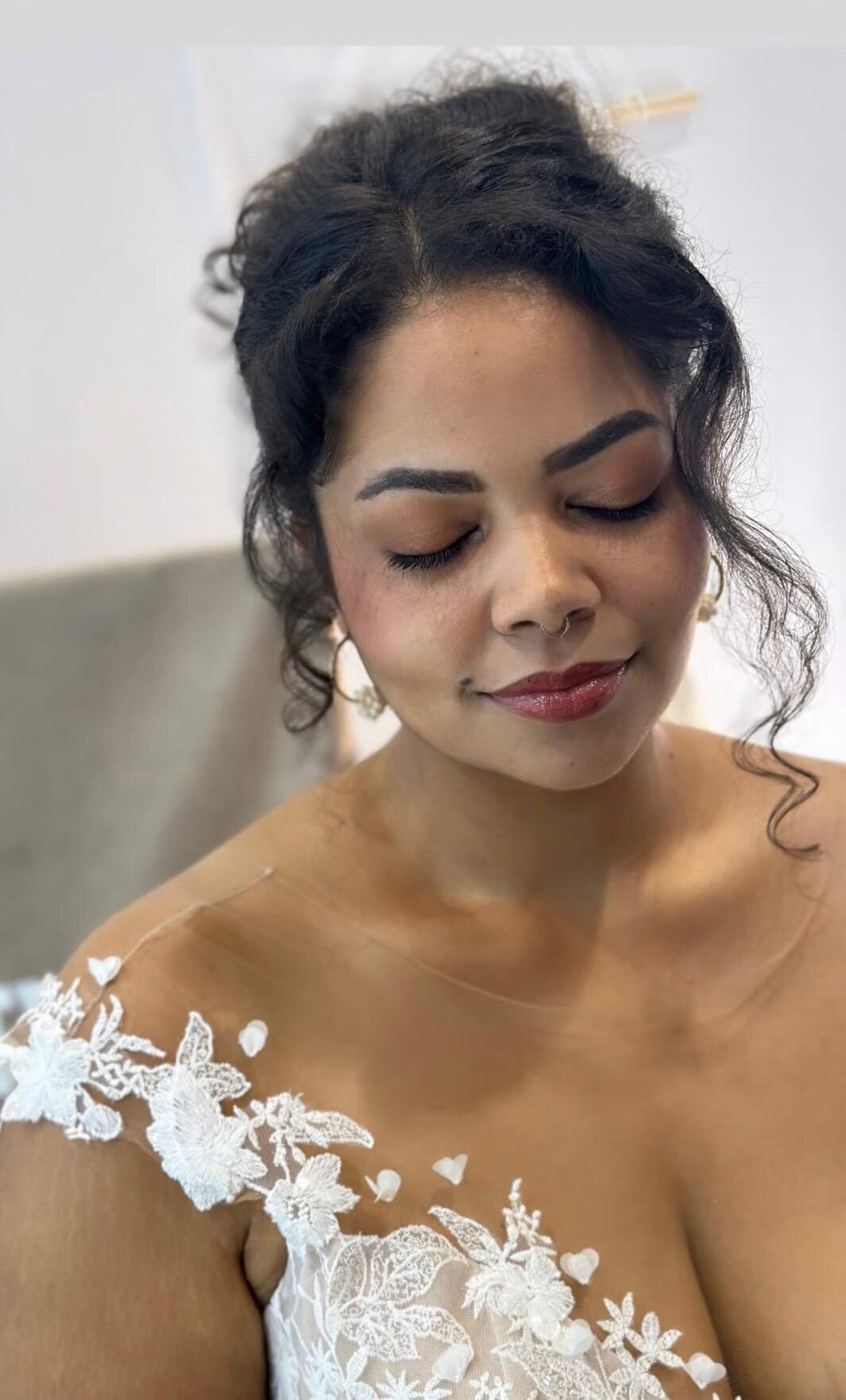 Braut mit warmem, natürlichem Make-up, geschlossenen Augen und weich definierten Locken