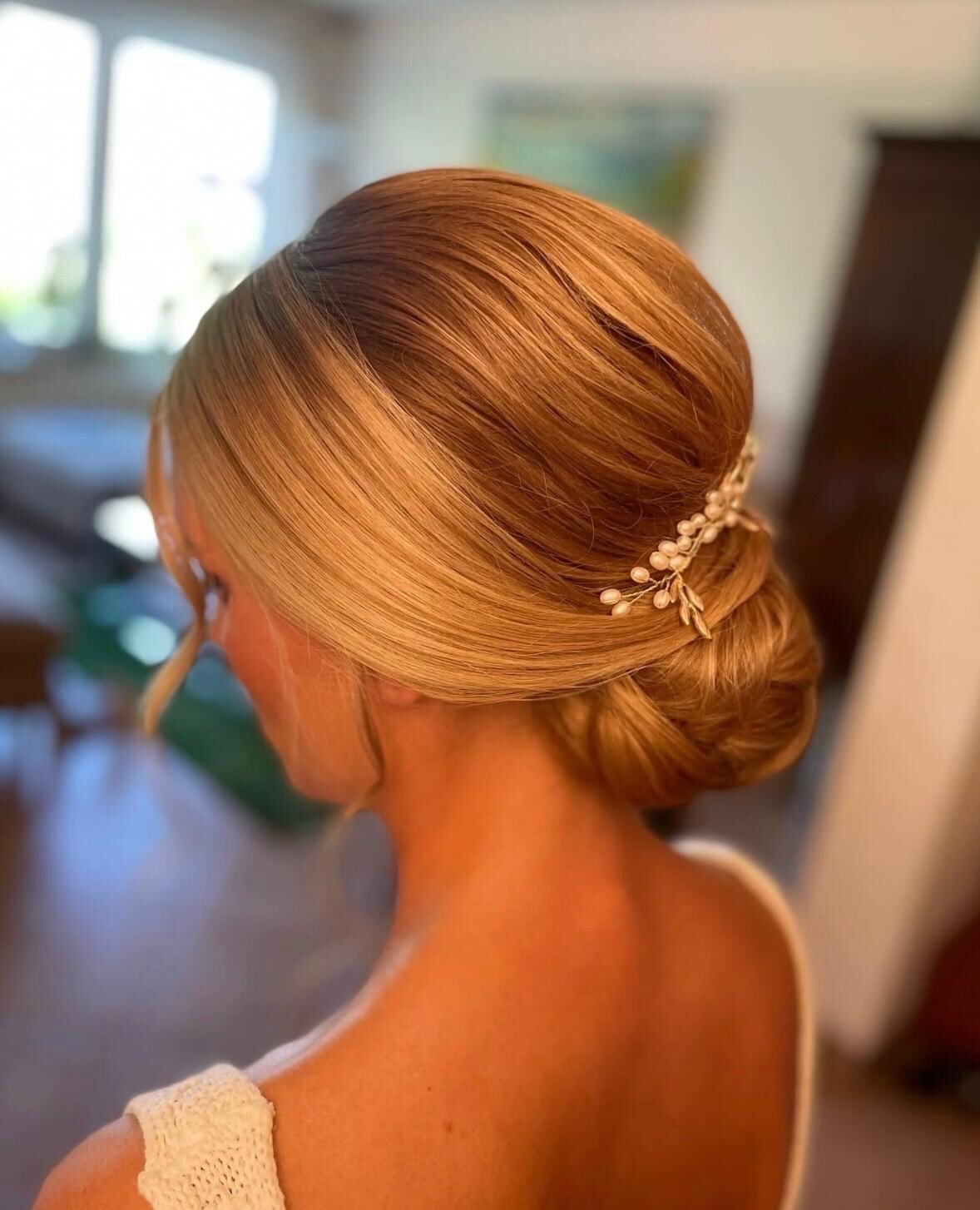 Glatter, tief sitzender Chignon in kupferblondem Haar mit goldener Blatt-Haarnadel